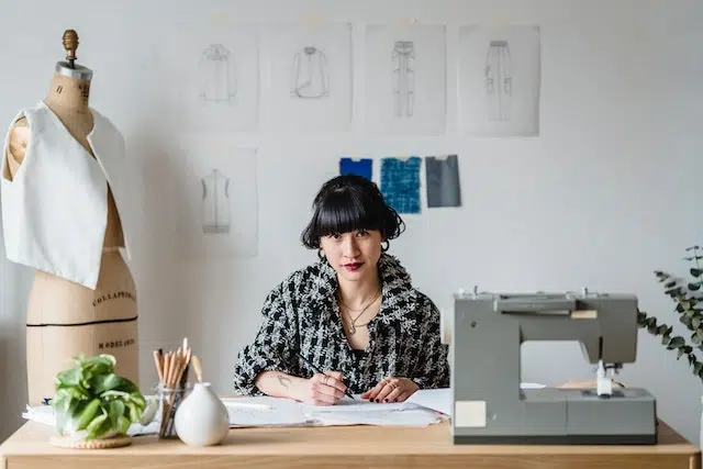 Pequena empreendedora com máquina de costura estudando como vender mais em pequenas empresas