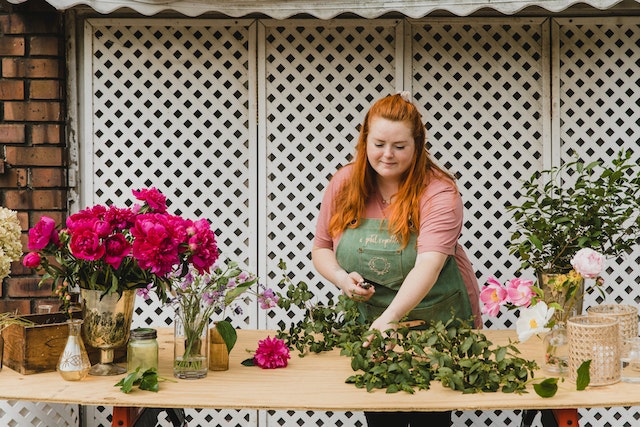 vender mais em pequenas empresas vendedora de flores arrumando seus produtos