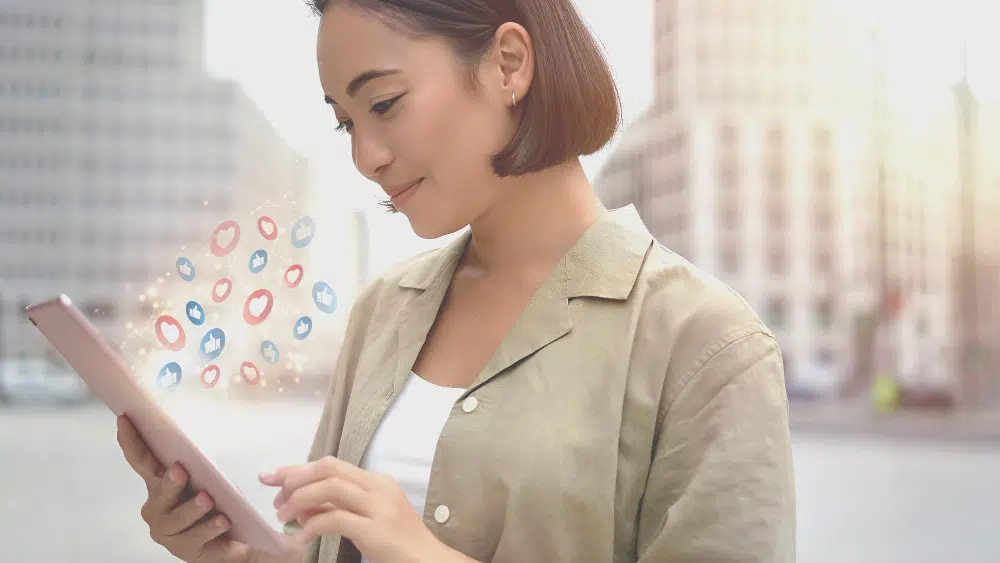 uma mulher asiática com um tablet na mão live marketing