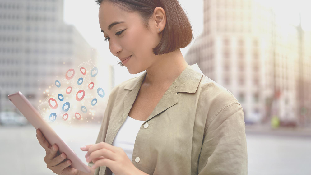 uma mulher asiática com um tablet na mão live marketing
