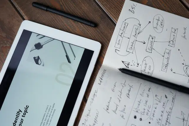 um ipad sobre a mesa, com uma folha com anotações sobre inbound marketing